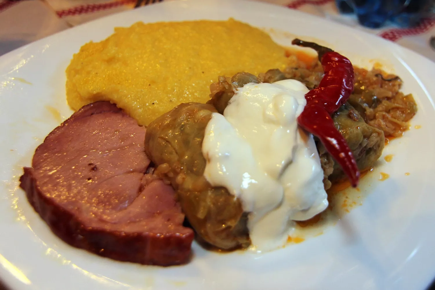 Sarmale with cream, mămăligă, smoked meat and hot peppers - Romanian dish